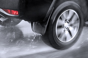 Close-up of rear wheel of car hydroplaning