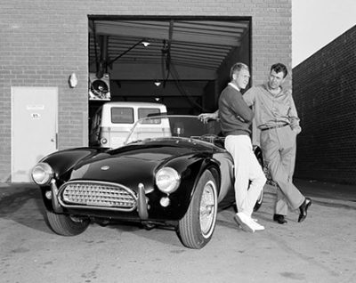 Actor Steve McQueen and Carroll Shelby stand by McQueen's Ford AC Cobra roadster, June 28, 1963, Los Angeles, CA.