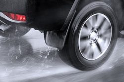 Close-up of rear wheel of car hydroplaning